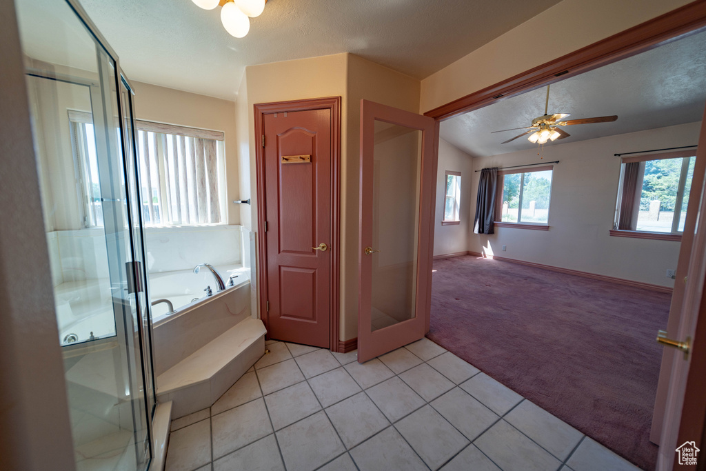 Bathroom featuring a garden tub, a shower stall, ceiling fan, and tile patterned floors