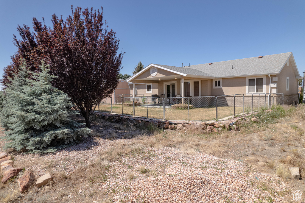 Rear view of house featuring a fenced backyard and stucco siding