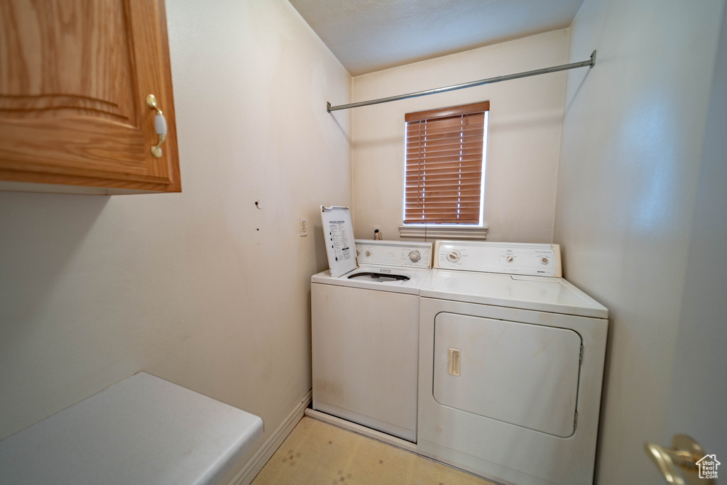 Washroom featuring cabinet space and washing machine and dryer