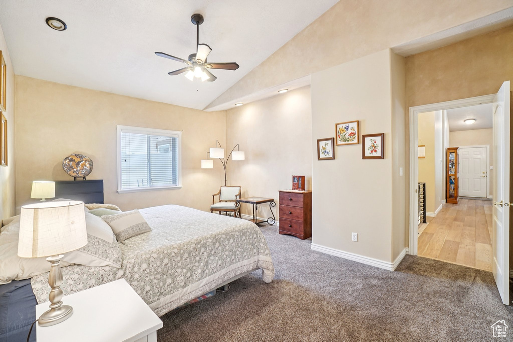 Carpeted bedroom with vaulted ceiling and a ceiling fan