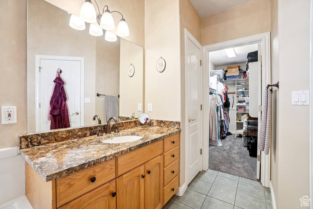Bathroom with vanity, tile patterned flooring, and a spacious closet