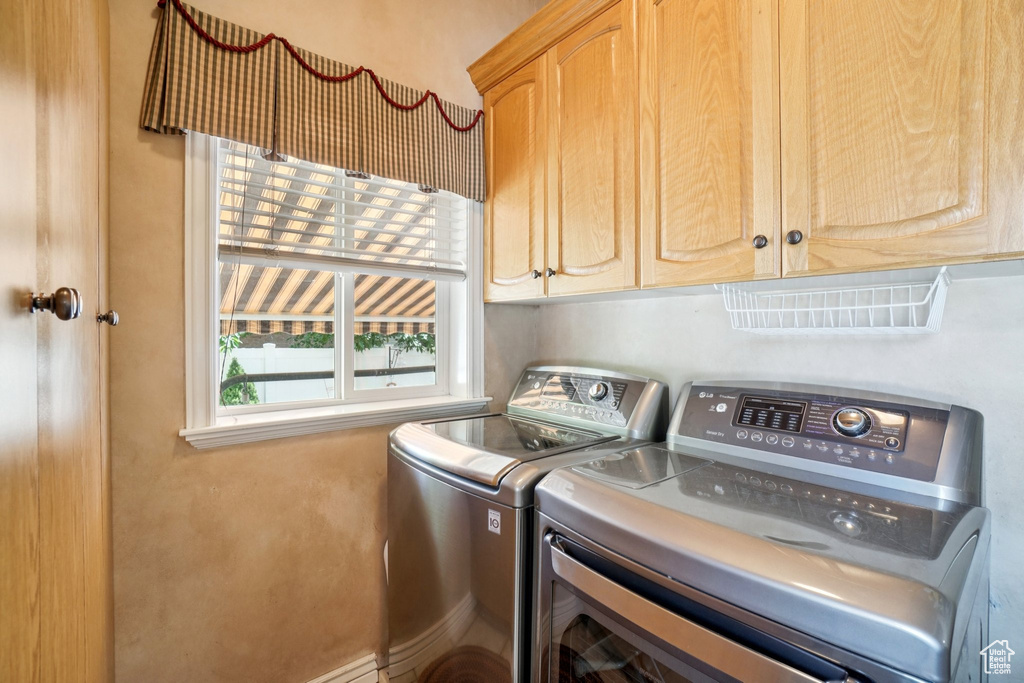Laundry room with washer and clothes dryer and cabinet space
