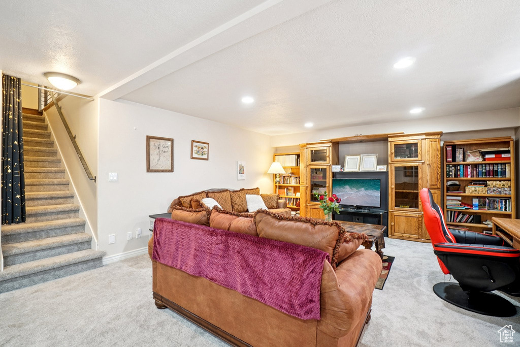 Living area with light colored carpet, stairway, and recessed lighting
