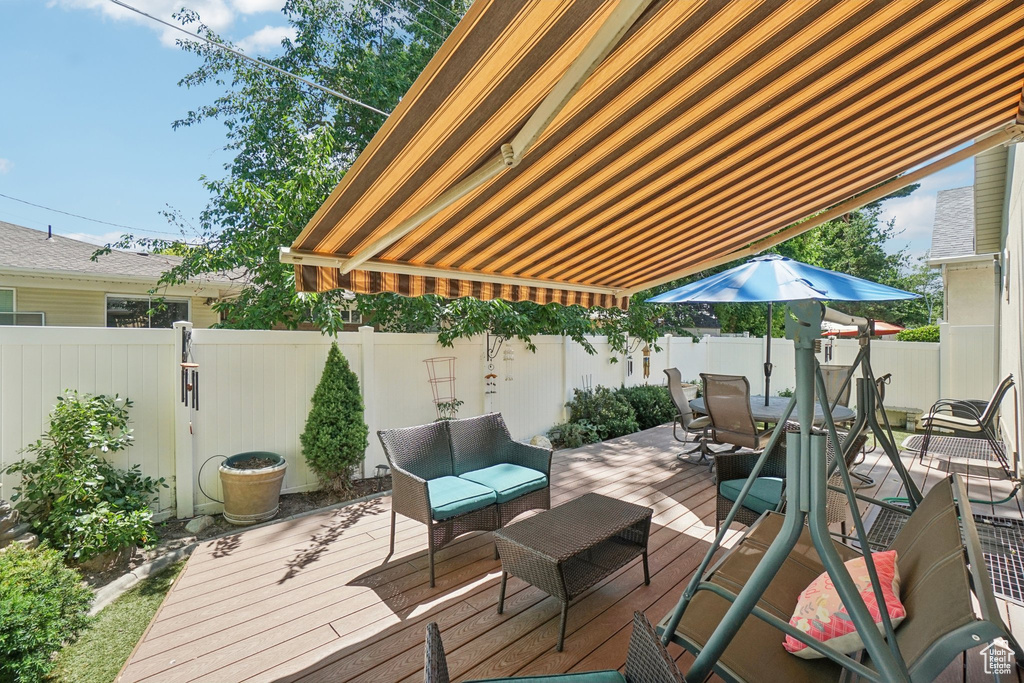Wooden deck featuring a fenced backyard, outdoor lounge area, and outdoor dining space