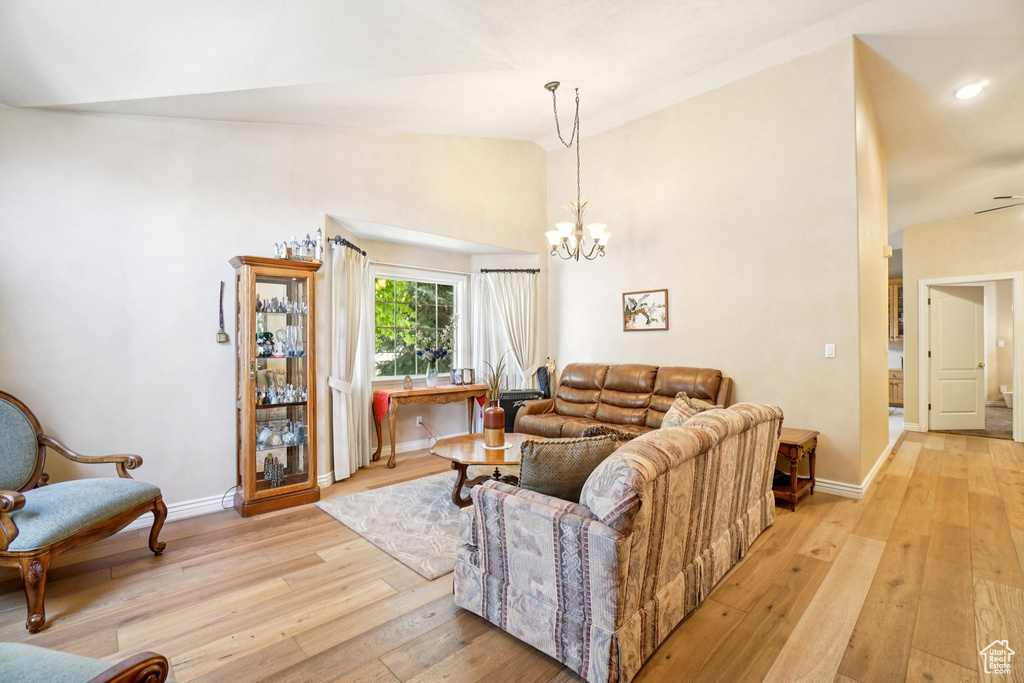 Living room with lofted ceiling, light wood-style flooring, a chandelier, and recessed lighting