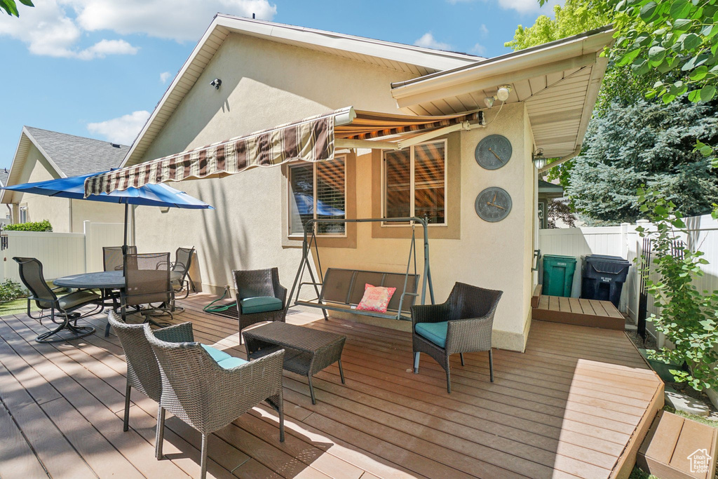 Wooden terrace with a fenced backyard and outdoor dining space