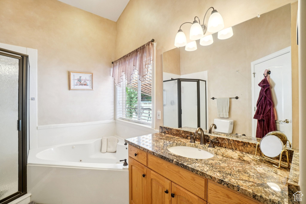 Full bath with a stall shower, vanity, and a jetted tub