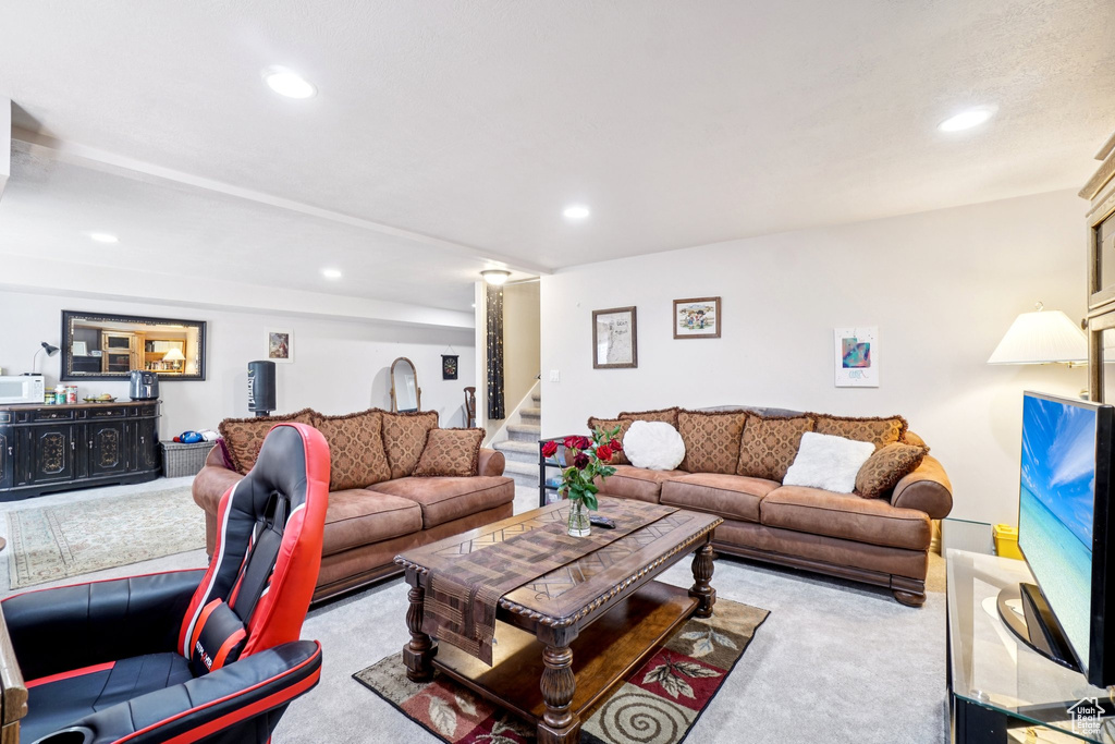 Living area with carpet flooring, stairway, and recessed lighting