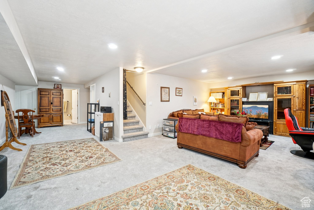 Living room featuring carpet flooring, stairs, and recessed lighting