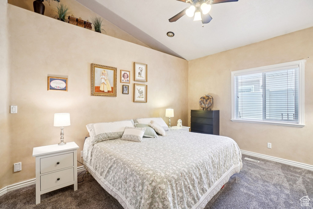 Bedroom with dark carpet, lofted ceiling, and ceiling fan