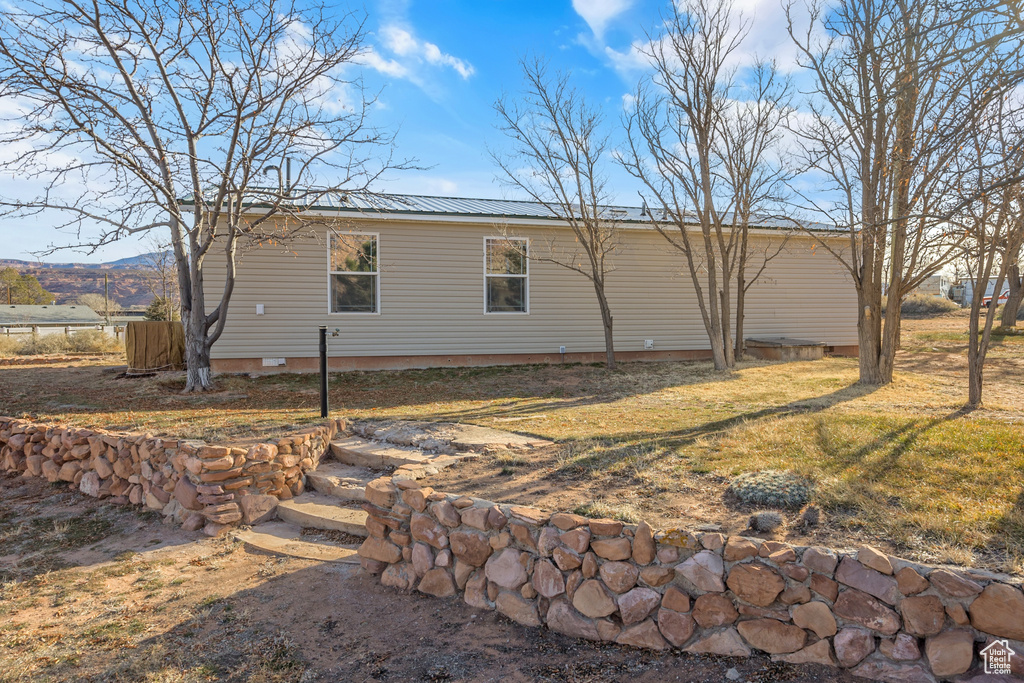View of home\'s exterior featuring crawl space, a metal roof, and a yard