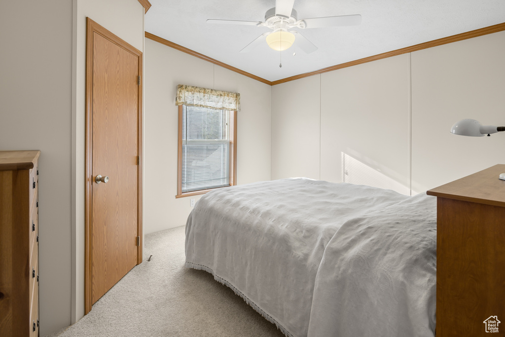 Bedroom with carpet flooring, crown molding, lofted ceiling, and ceiling fan