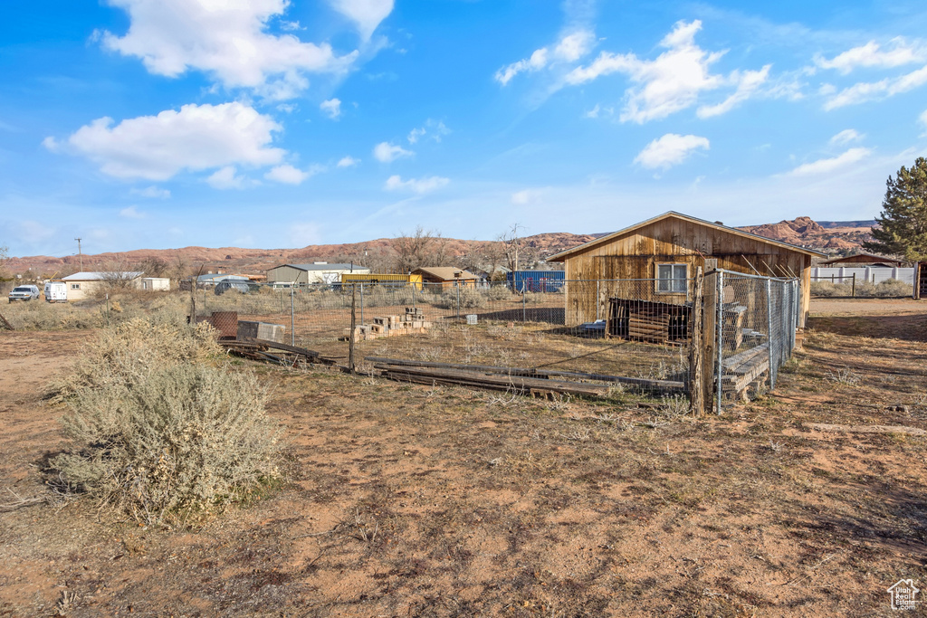 View of yard featuring exterior structure, an outdoor structure, and a mountain view