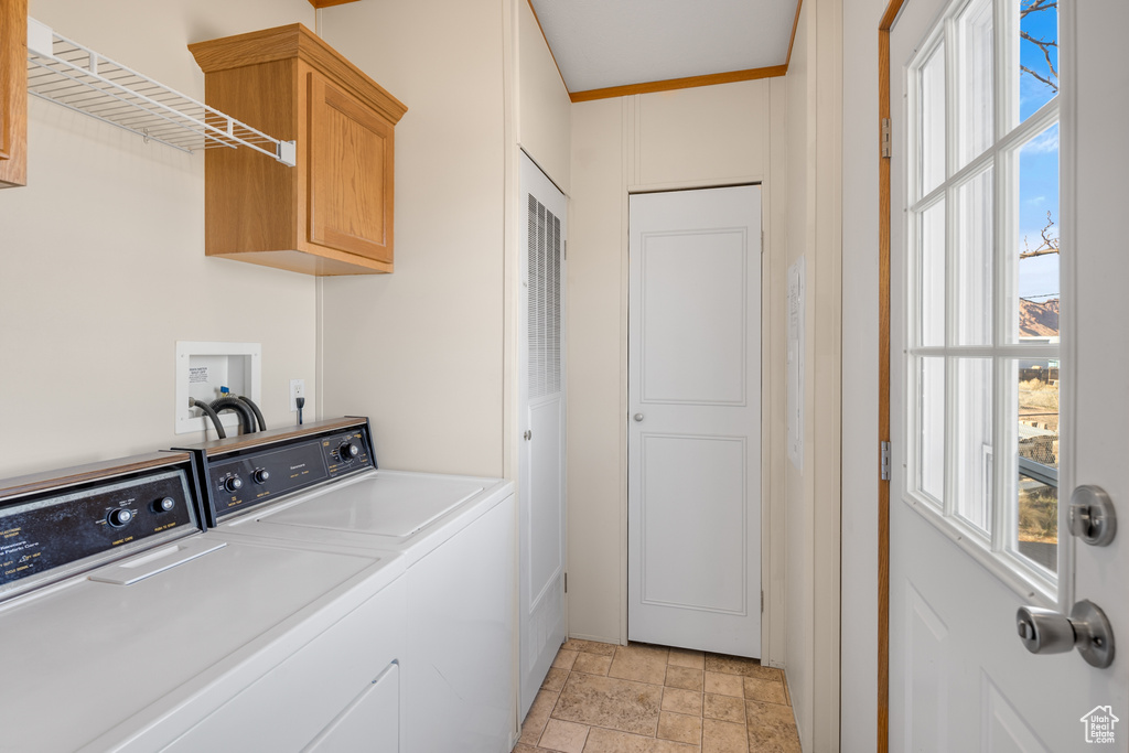 Laundry room featuring cabinet space, washing machine and dryer, and light stone finish floors