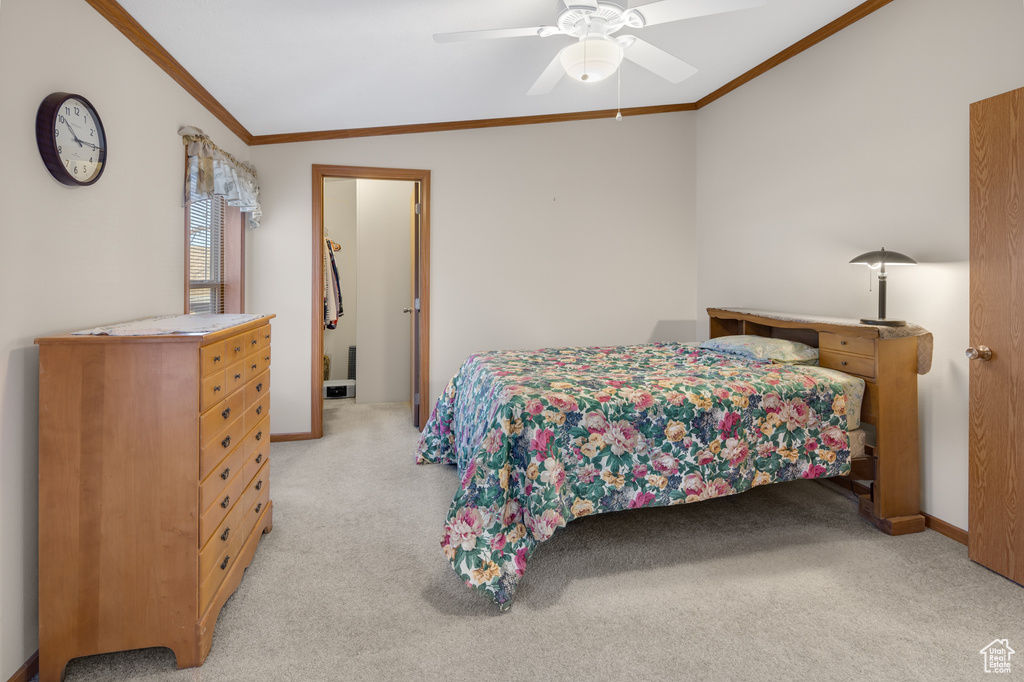 Bedroom with crown molding, light carpet, and ceiling fan
