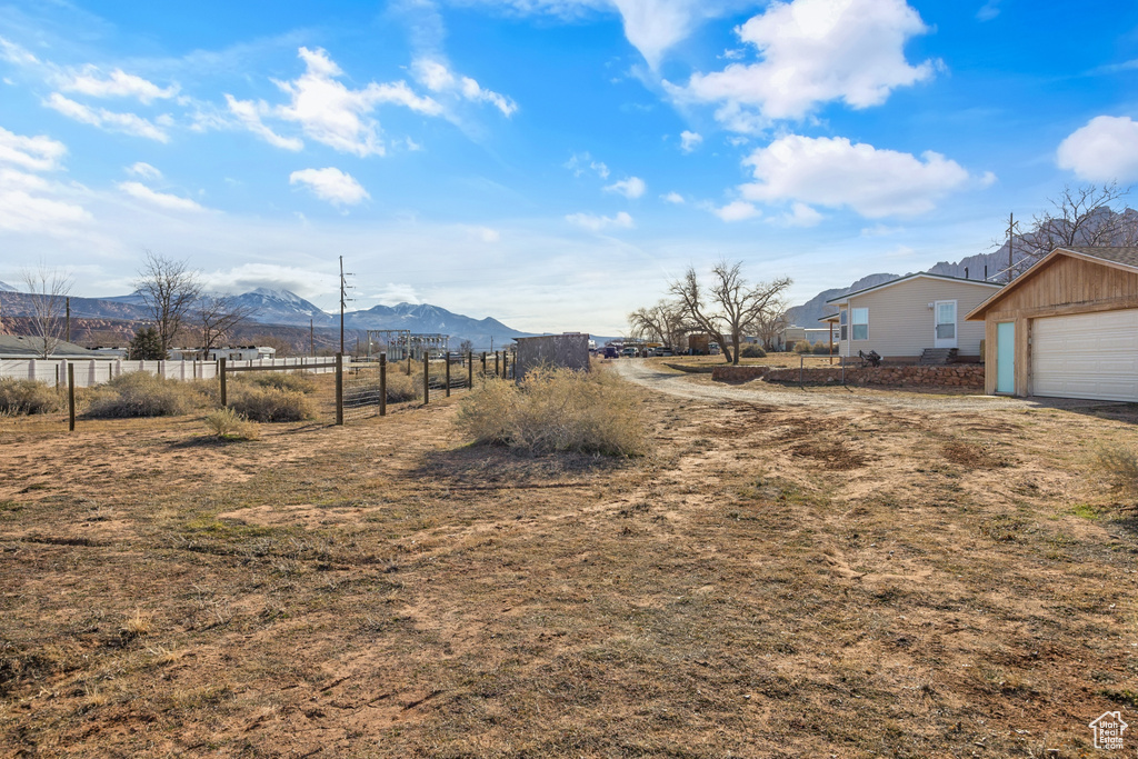 View of yard with a mountain view, a garage, and an outbuilding