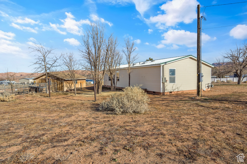 Back of house featuring crawl space and a metal roof