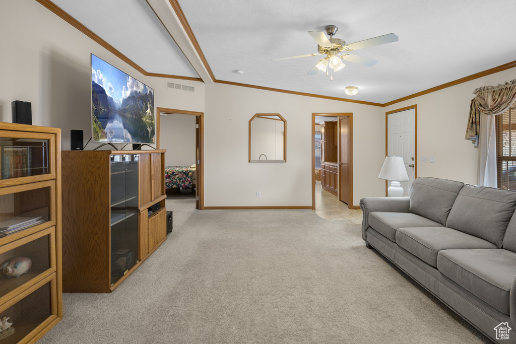 Living area featuring light carpet, ceiling fan, and crown molding