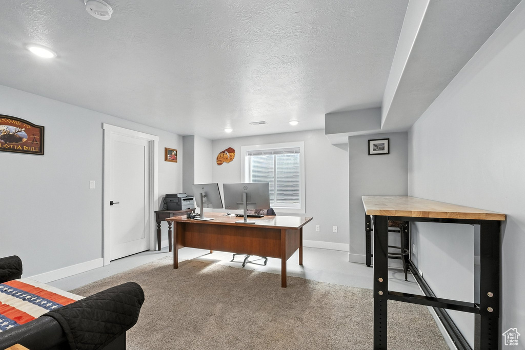 Office area featuring a textured ceiling, recessed lighting, and carpet flooring