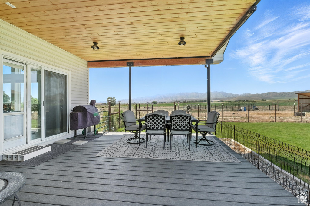 Wooden terrace with a mountain view, grilling area, and outdoor dining area