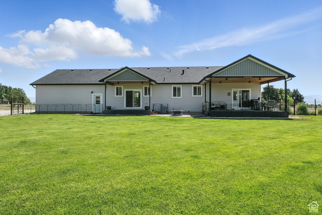 Rear view of house with a patio area and a shingled roof