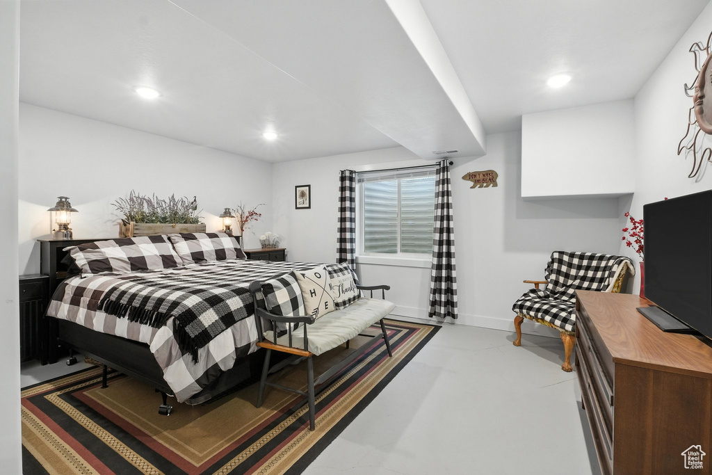 Bedroom featuring finished concrete flooring and recessed lighting
