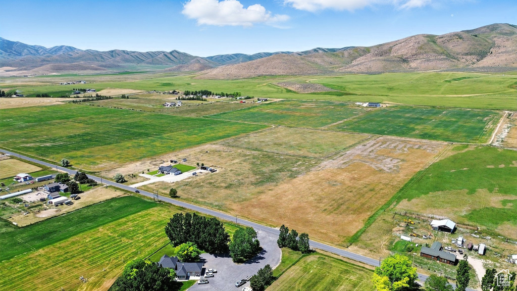 Aerial view of property and surrounding area featuring rural landscape and a mountainous background