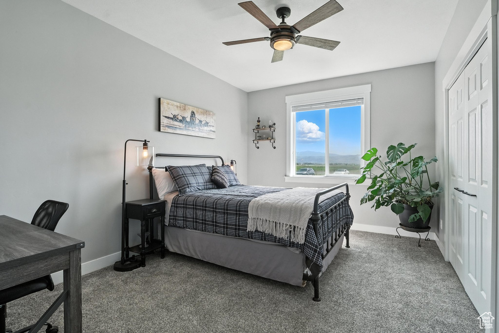 Carpeted bedroom featuring a closet and a ceiling fan