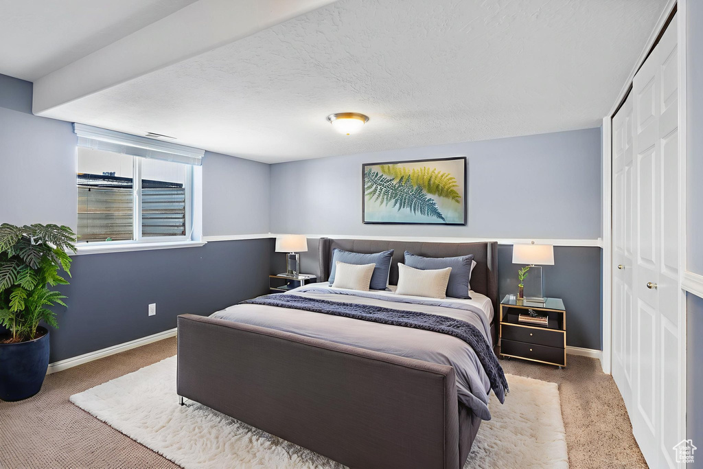 Carpeted bedroom with baseboards and a closet