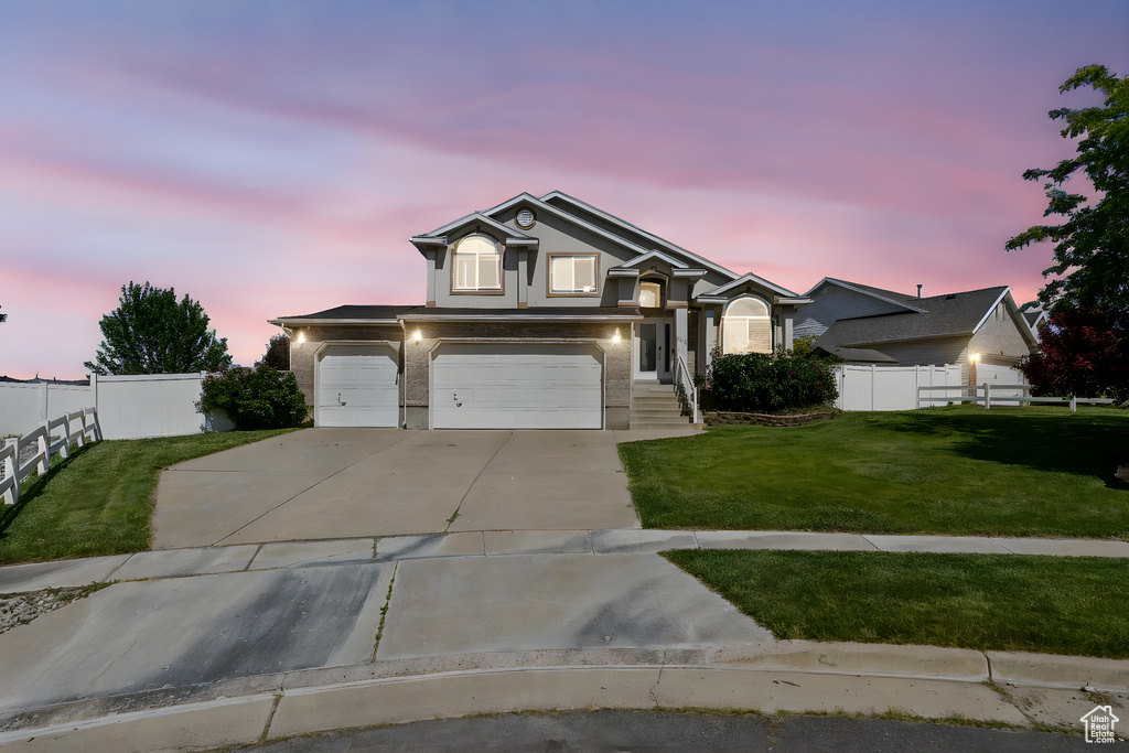 View of front facade featuring driveway, an attached garage, and stucco siding
