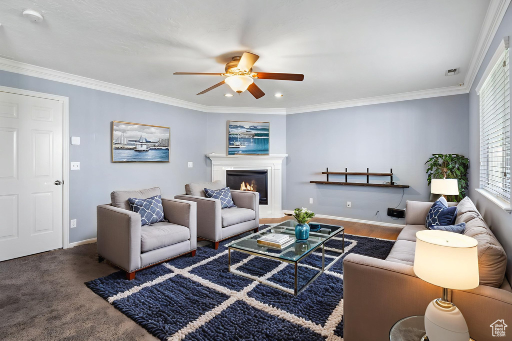 Living room with a ceiling fan, a glass covered fireplace, ornamental molding, and recessed lighting