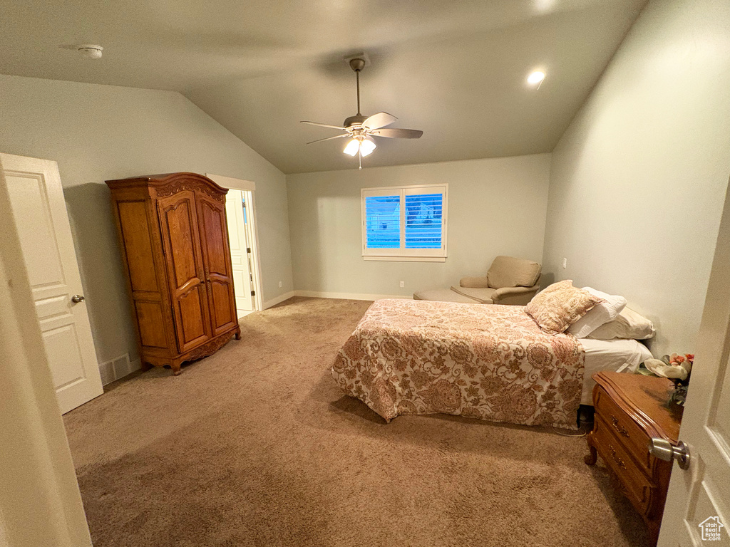 Bedroom featuring light carpet, lofted ceiling, and ceiling fan