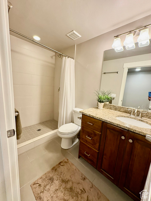Full bath featuring vanity, tile patterned floors, and a tile shower