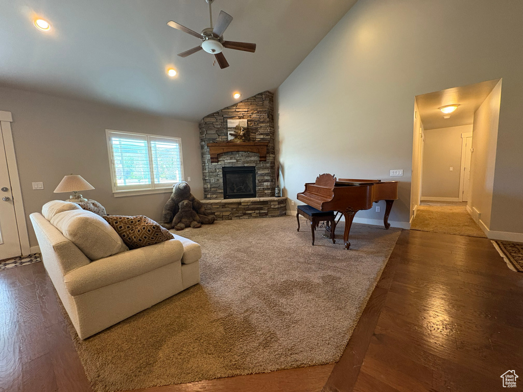 Living area featuring ceiling fan, a fireplace, wood finished floors, high vaulted ceiling, and recessed lighting