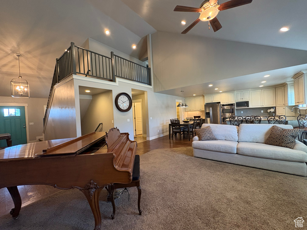 Living area featuring ceiling fan, high vaulted ceiling, recessed lighting, and a chandelier