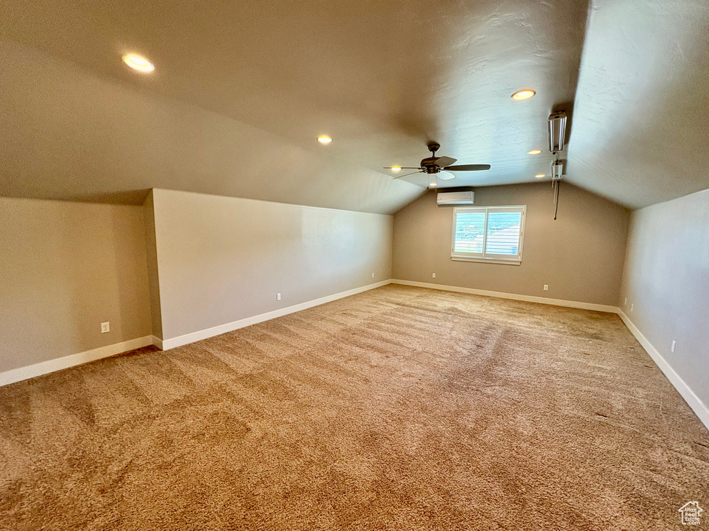 Bonus room featuring lofted ceiling, carpet flooring, ceiling fan, an AC wall unit, and recessed lighting