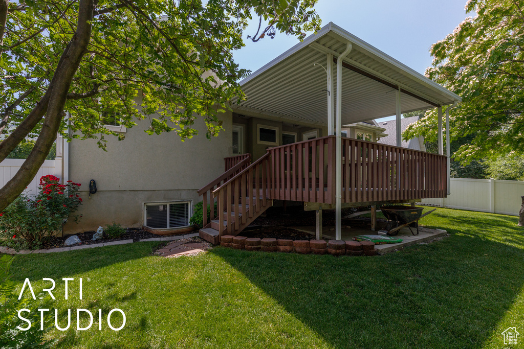 Rear view of property featuring a wooden deck, stairway, and stucco siding