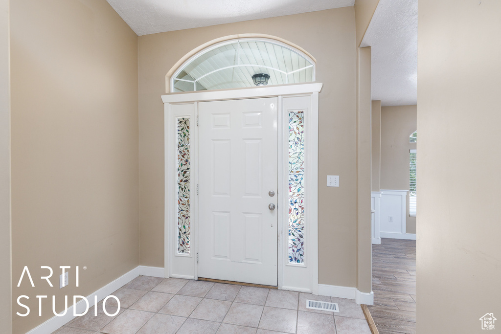 Entrance foyer with baseboards and light tile patterned floors