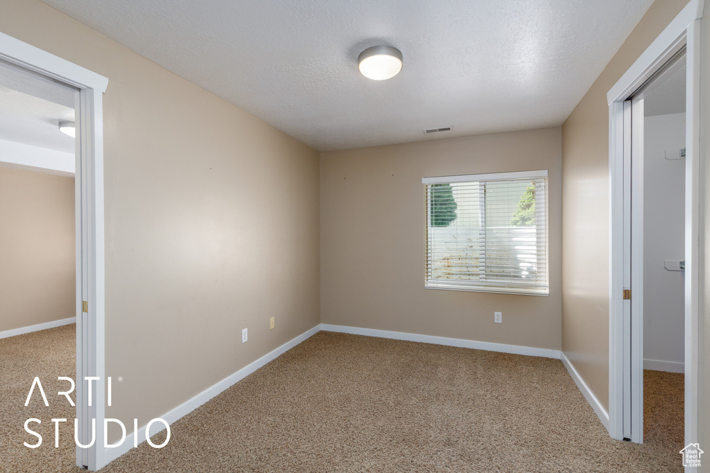 Carpeted empty room with baseboards