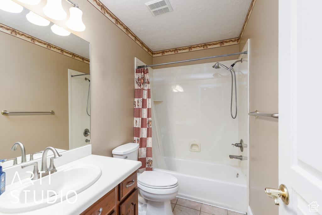 Full bathroom featuring vanity, shower / bathtub combination with curtain, tile patterned floors, and a textured ceiling