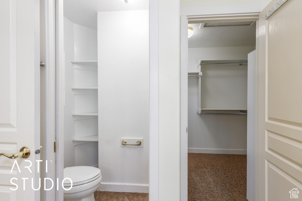 Bathroom with toilet and a textured ceiling