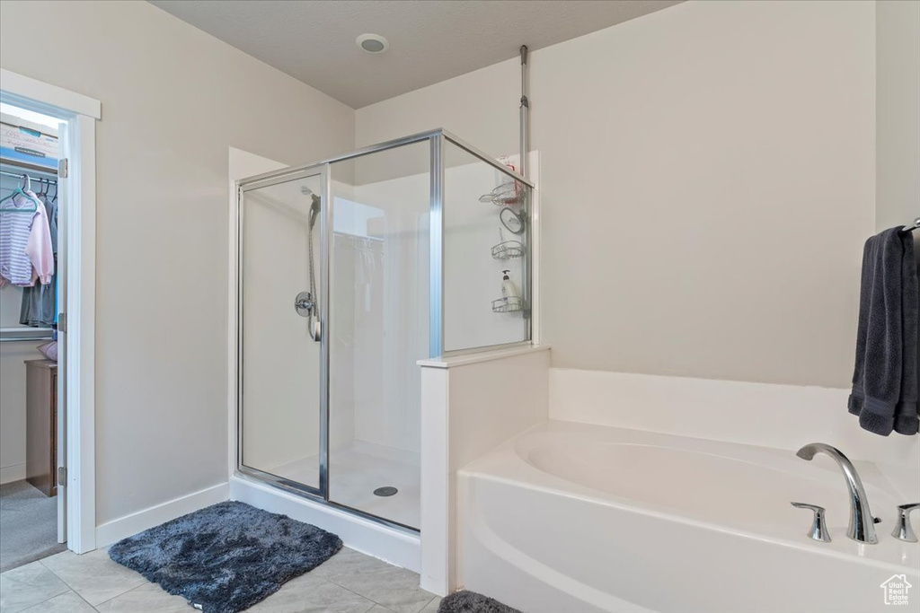 Full bath with a shower stall, a bath, and tile patterned flooring