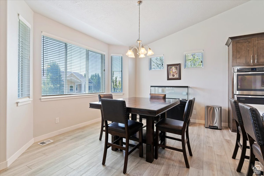 Dining area featuring a chandelier, plenty of natural light, and light wood-style flooring