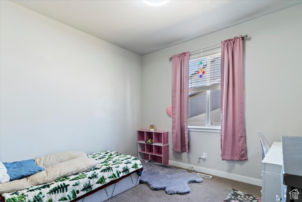 Bedroom featuring carpet floors and baseboards