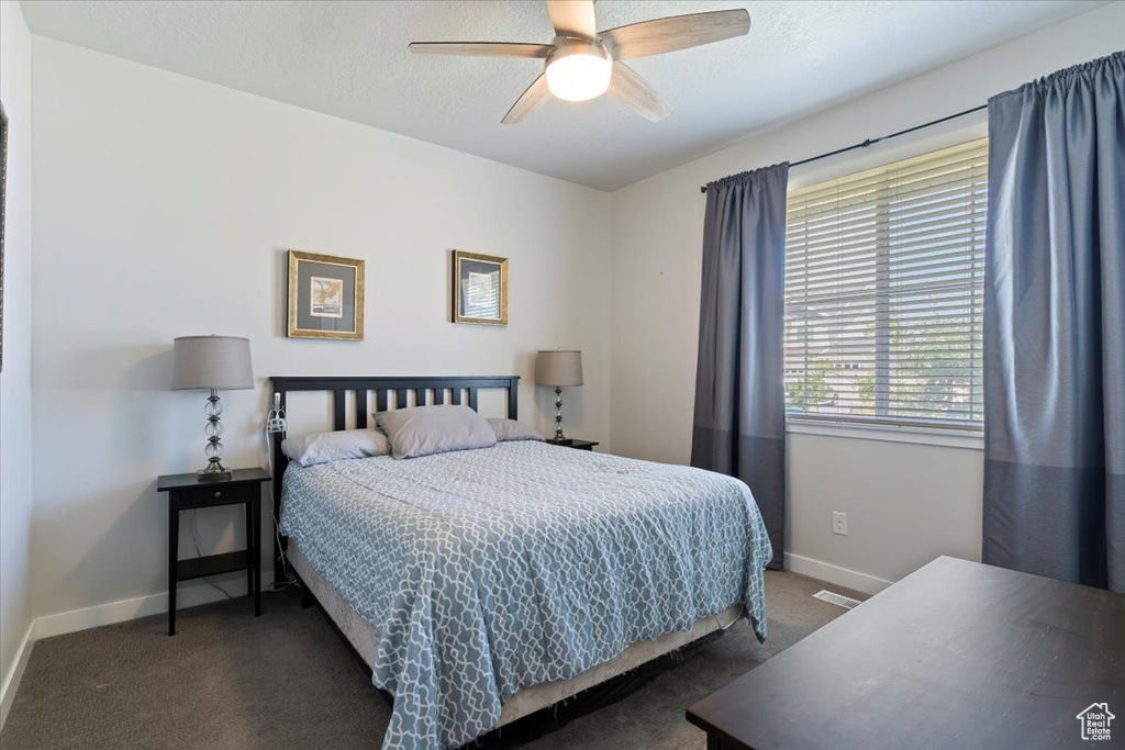 Carpeted bedroom featuring baseboards and ceiling fan