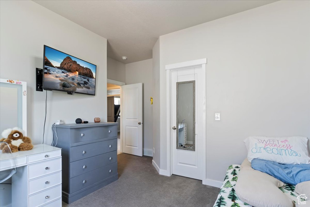 Bedroom featuring dark colored carpet and baseboards