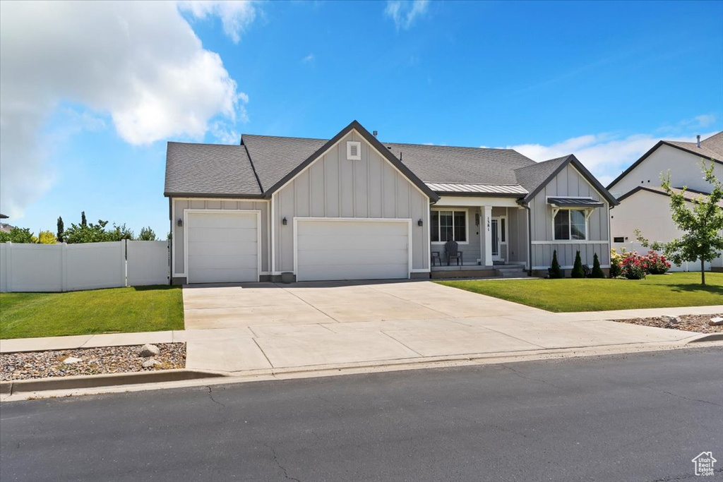 View of front of property featuring board and batten siding, a garage, concrete driveway, roof with shingles, and a porch
