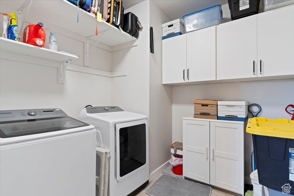Laundry area featuring washer and clothes dryer and cabinet space