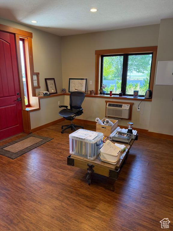 Living area featuring wood finished floors, recessed lighting, a desk, and an AC wall unit