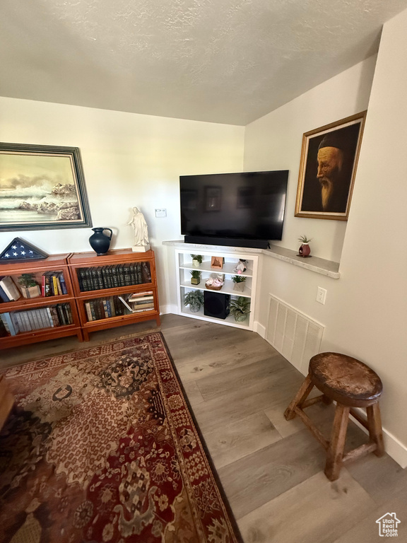 Living area with wood finished floors and a textured ceiling